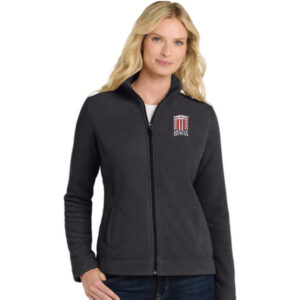 Woman wearing a dark zip-up fleece with The City of Benicia logo on the left chest.